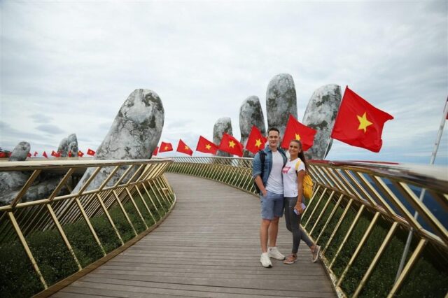 Rất nhiều du khách ngoài nước ấn tượng với hình ảnh những lá cờ phấp phới trên cây Cầu Vàng